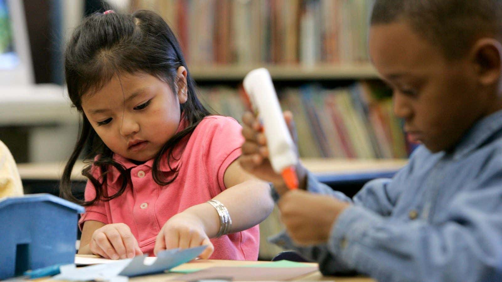 Nyah Ly, left, and Maurice Smith, right, make houses for a geography lesson in Kim Salay’s all-day kindergarten class at Highland Elementary School in Apple…