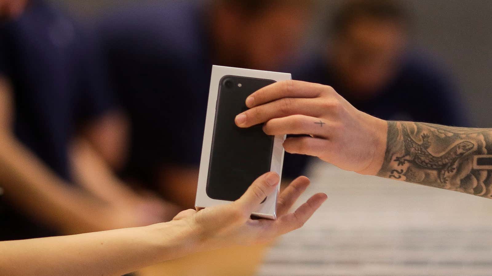 Apple shop staff hand out the new iPhone 7 to customers at the Apple store in Berlin, Friday, Sept. 16, 2016. Apple’s newest mobile devices,…