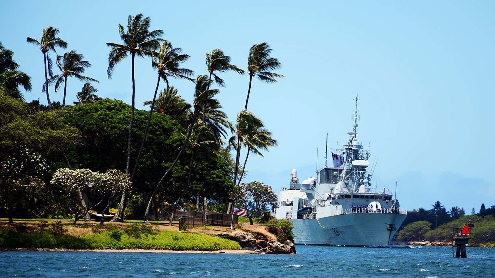 A frigate pulls into Pearl Harbor.