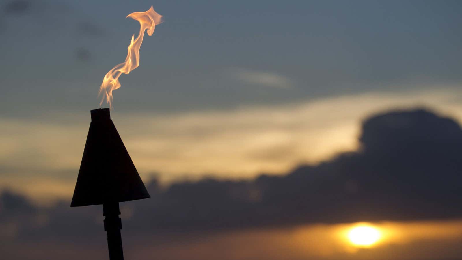 A tiki torch burns at sunset in Kahana, Maui, Hawaii July 30, 2015.  REUTERS/Marco Garcia – GF20000009573