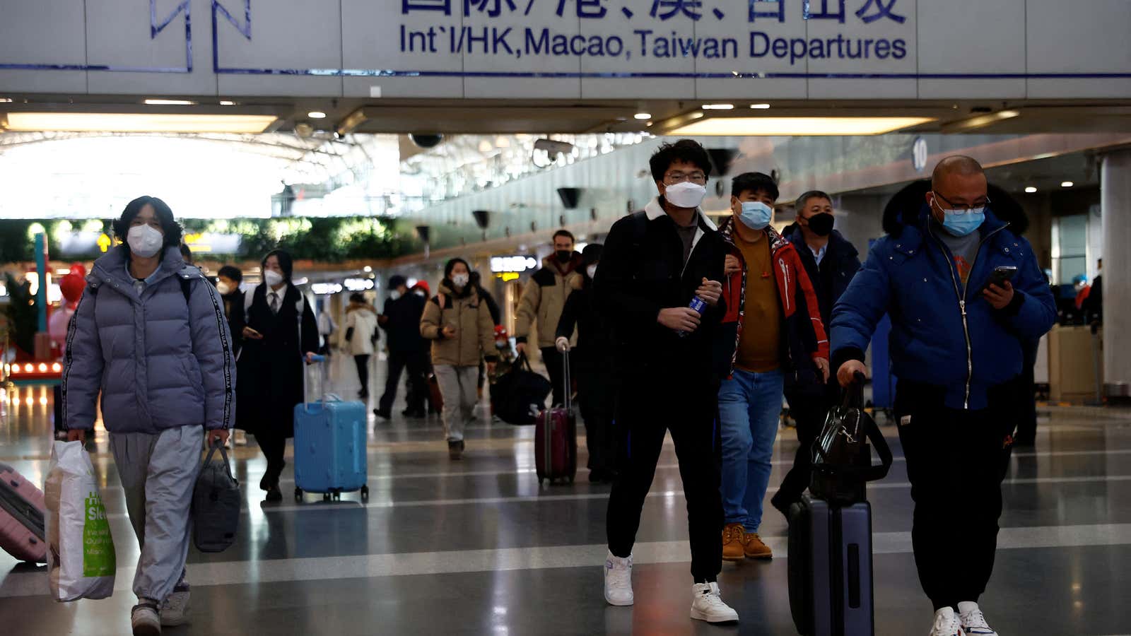 Travelers walk with their luggage at Beijing Capital International Airport in Beijing, China on December 27, 2022.