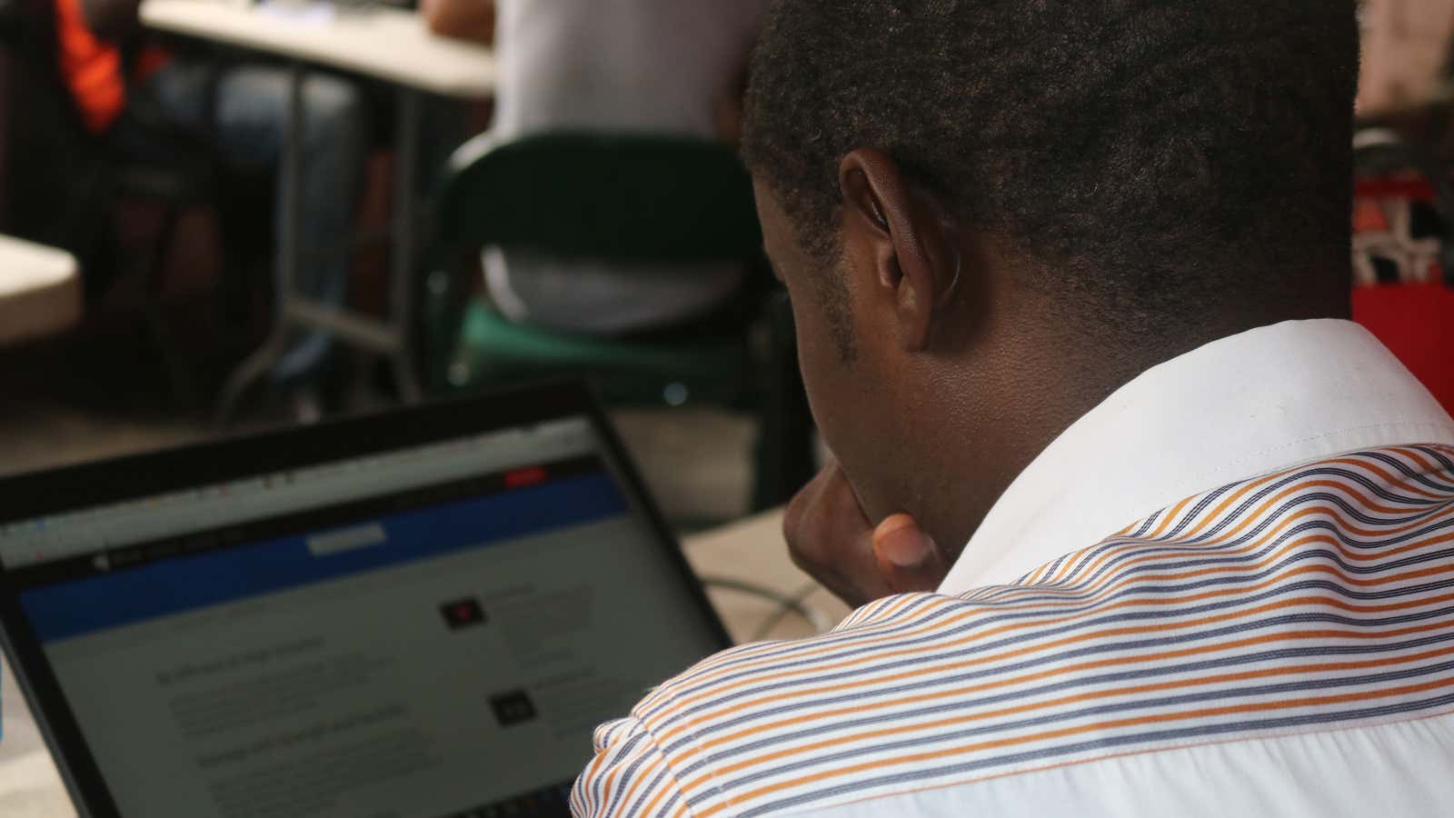 Young startup worker on a laptop in New Bonako village, Cameroon