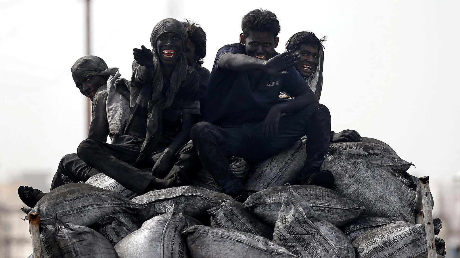 FILE PHOTO: Coal workers travel on the back of their lorry in Barsana, India, June13, 2017. REUTERS/Cathal McNaughton/File Photo