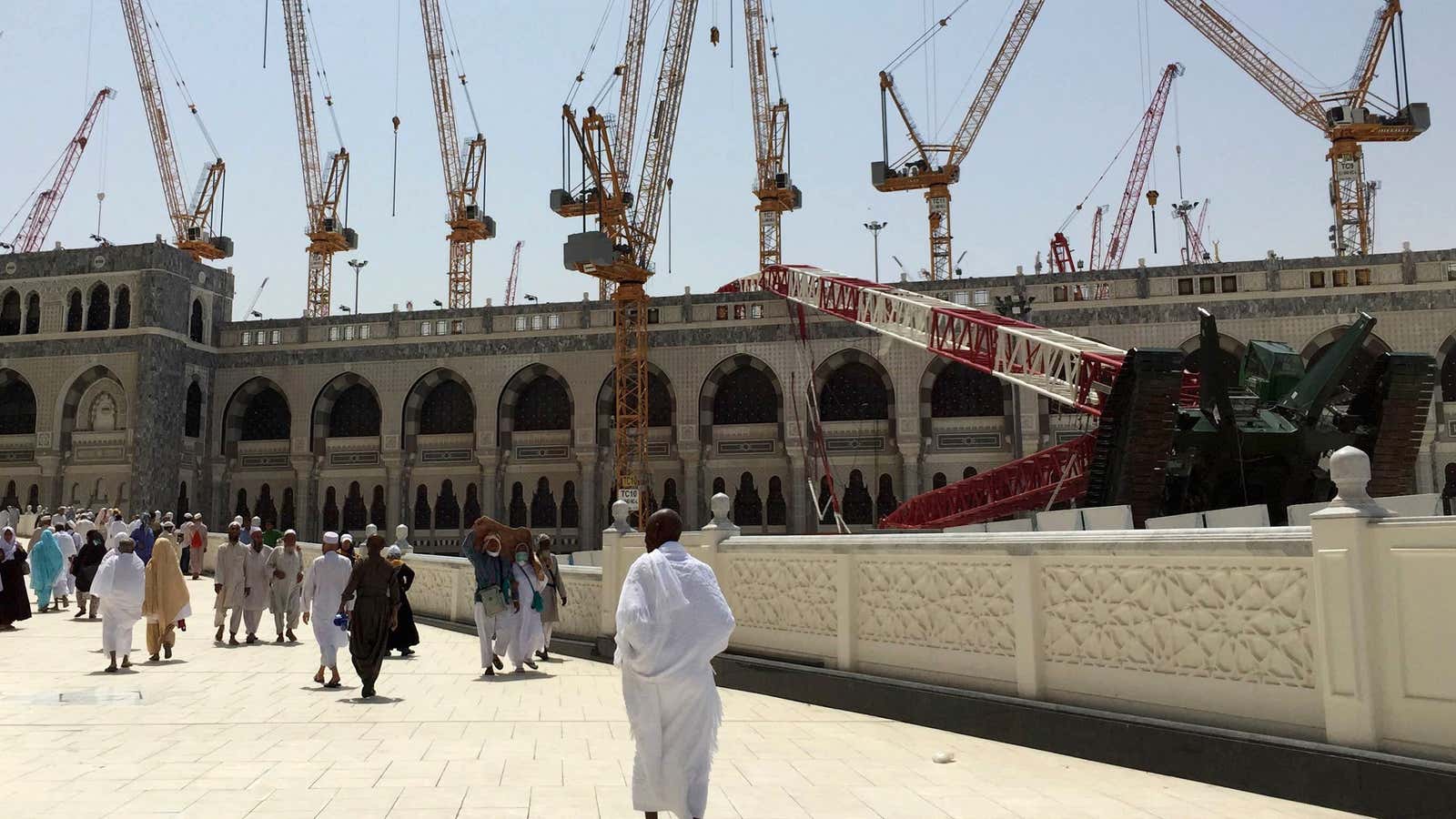 Muslim pilgrims walk near a construction crane which crashed into the Grand Mosque on Sept. 12, 2015.