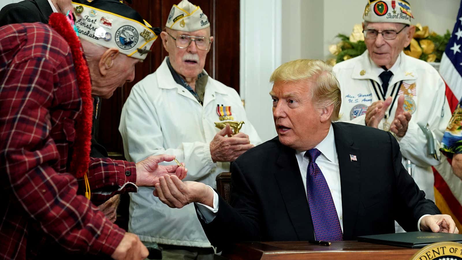 Lawrence Parry, a veteran of Pearl Harbor, shows Trump a challenge coin during a proclamation ceremony for National Pearl Harbor Day on December 7, 2017.