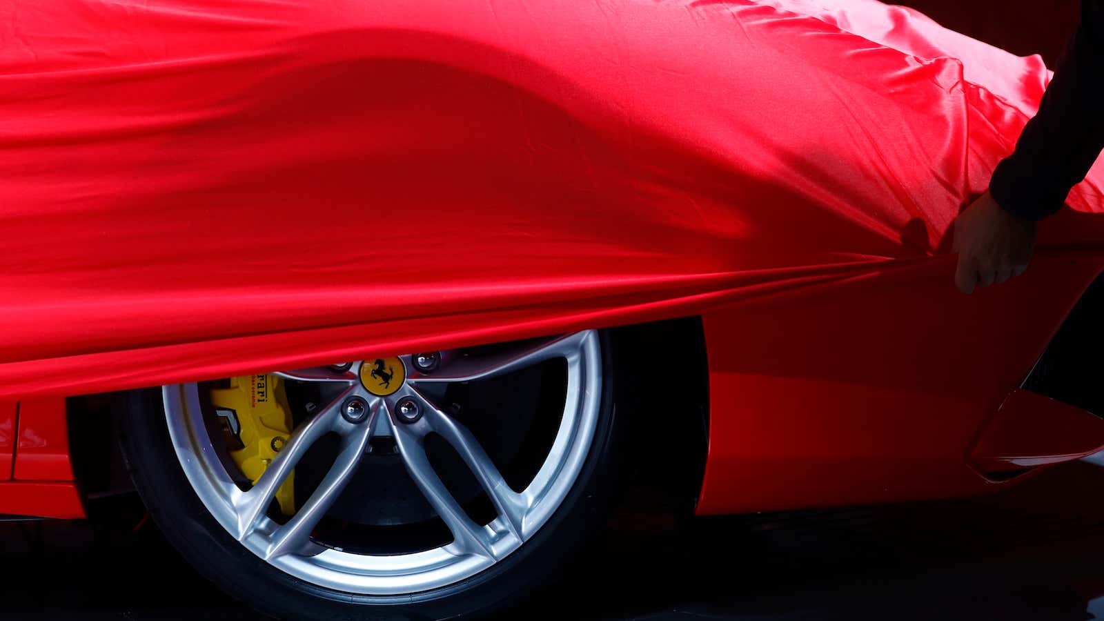 A partially covered Ferrari car is pictured before the opening  of the Frankfurt Motor Show (IAA) in Frankfurt, Germany September 11, 2017. REUTERS/Kai Pfaffenbach – UP1ED9B0QPRMN