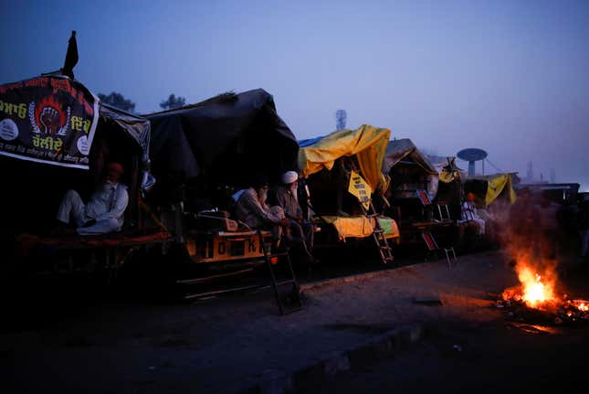 Farmers sleeping in their modified tractor trolleys.