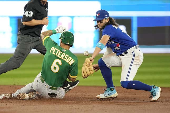 Jun 24, 2023; Toronto, Ontario, CAN; Oakland Athletics third baseman Jace Peterson (6) slides safely into second base on a double as Toronto Blue Jays shortstop Bo Bichette (11) misses the catch in during the second inning at Rogers Centre.