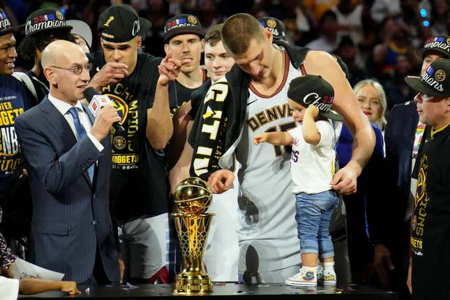 Jun 12, 2023; Denver, Colorado, USA; Denver Nuggets center Nikola Jokic (15) and his daughter point to the Bill Russell NBA Finals MVP Award trophy after winning the 2023 NBA Finals against the Miami Heat at Ball Arena.