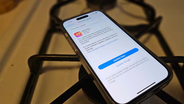 iPhone 14 Pro on top of the stove with the screen showing the latest iOS 17.0.3 patch.