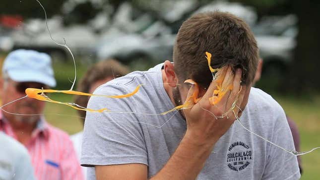 Person smashing an egg against their face, with the yolk flying everywhere