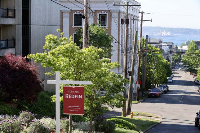 A "For Sale" sign is posted outside a residential home in the Queen Anne neighborhood of Seattle, Washington, U.S. May 14, 2021.