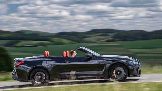 A photo of a black BMW M4 Competition Convertible with its roof down. 