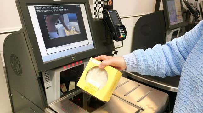Grocery store shopper using self-checkout lane, scanning item