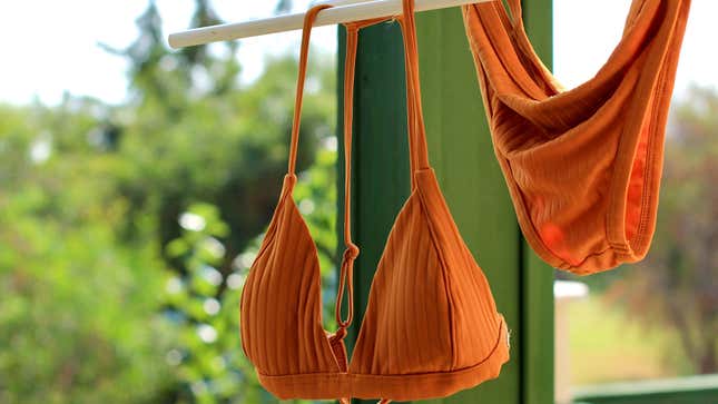 Orange bikini swimsuit hanging on line to dry