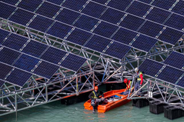 FILE - Workers assemble floating barges with solar panels on the &#39;Lac des Toules&#39;, an alpine reservoir lake, in Bourg-Saint-Pierre, Switzerland, Tuesday, Oct. 8, 2019. Voters in a southern Swiss region cast their ballots Sunday, Sept. 10 2023, to decide whether to allow large solar parks on their sun-baked Alpine mountainsides as part of the federal government’s push to develop renewable energies. (Valentin Flauraud/Keystone via AP, File)