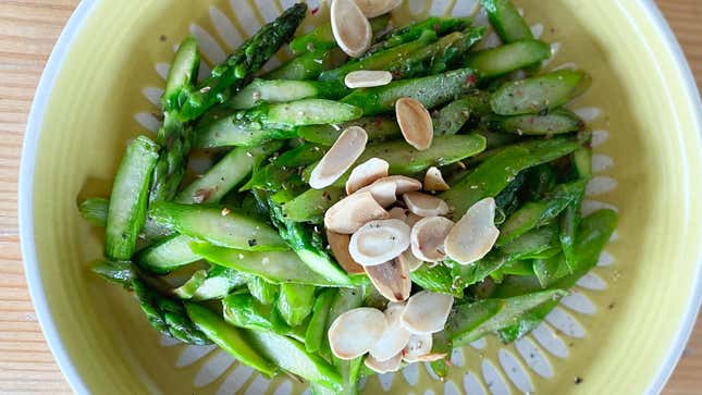 Sautéed asparagus cut on the bias with pepper and almonds on a plate 