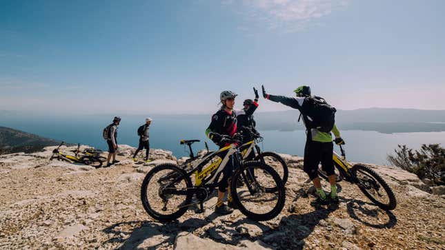 A photo of people high fiving after riding their Greyp e-bikes. 