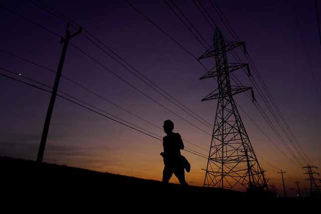 FILE - A jogger passes power lines during a sunset run, Aug. 20, 2023, in San Antonio, as high temperatures continue to stress the power grid. On Thursday, Sept. 7, Texas&#39; power grid manager again asked residents to cut back on electricity as a prolonged and punishing summer heat wave continued, a day after the system was pushed to brink of outages for the first time since a deadly winter blackout in 2021. (AP Photo/Eric Gay, File)