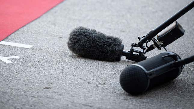 A photo of two microphones on the floor next to a red carpet. 