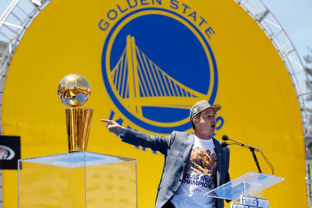 Jun 19, 2015; Oakland, CA, USA; Co-executive chairman and CEO Joe Lacob points towards the Larry O'Brien trophy during the Golden State Warriors 2015 championship celebration in downtown Oakland.