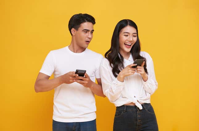 Two people excited about using their phones. 