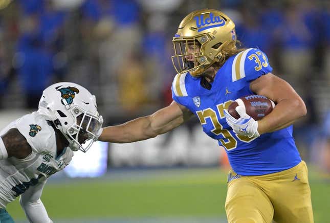 Sep 2, 2023; Pasadena, California, USA;  UCLA Bruins running back Carson Steele (33) pushes off Coastal Carolina Chanticleers safety Tobias Fletcher (4) for a first down in the first half at Rose Bowl.
