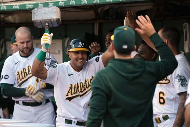 Jun 30, 2023; Oakland, California, USA; Oakland Athletics first baseman Carlos Perez (center) celebrates in the dugout while carrying a replica hammer after hitting a home run against the Chicago White Sox during the fifth inning at Oakland-Alameda County Coliseum.