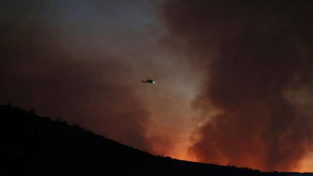 A fire department helicopter surveys the Rabbit Fire on July 14, 2023, in Moreno Valley, California. 