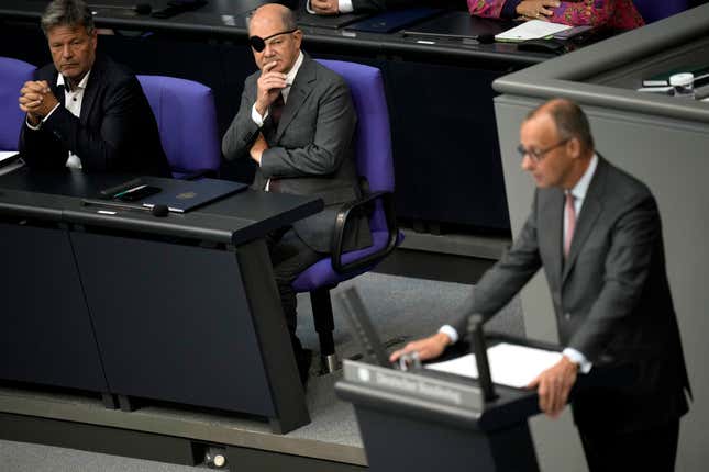Opposition Christian Union parties floor leader Friedrich Merz, right, speaks, as German Chancellor Olaf Scholz, centre, and Robert Habeck, Federal Minister for Economic Affairs and Climate Protection look on on the second day of the budget 2024 debate at the German parliament Bundestag in Berlin, Germany, Wednesday, Sept. 6, 2023. (AP Photo/Markus Schreiber)