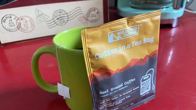Mug of coffee with bag that reads "coffee in a tea bag"
