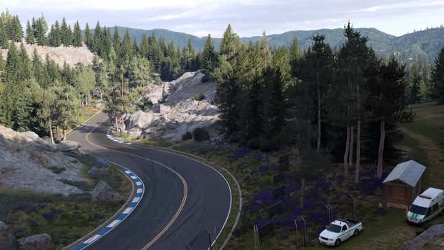 A screenshot from Gran Turismo 7 depicting a racetrack curving through a forest-y location.