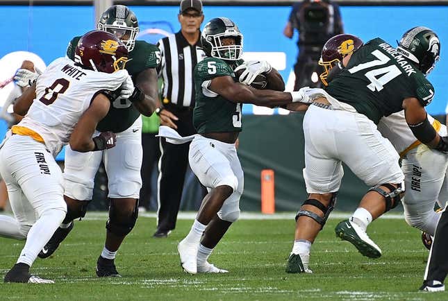Sep 1, 2023; East Lansing, Michigan, USA;  Michigan State Spartans running back Nathan Carter (5) runs through a hole in the Central Michigan Chippewas line in the second quarter at Spartan Stadium.