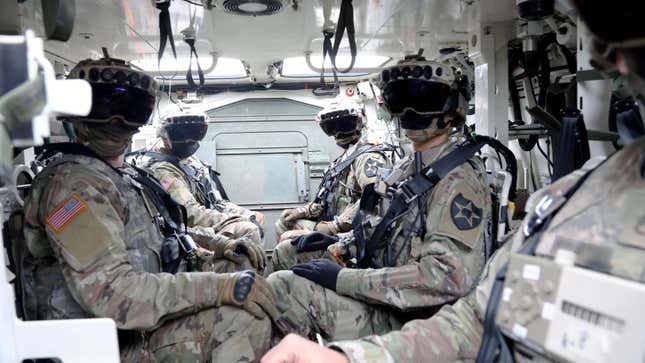Several soldiers sitting in a truck wearing large helmets with lenses and goggles. 