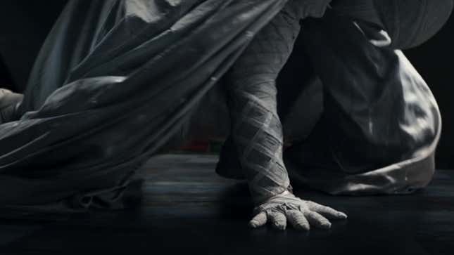 The white-robed hand of Marvel's Moon Knight steadies the superhero as he crouches in a three-point landing pose, in footage from Marvel Studios' Disney+ series.