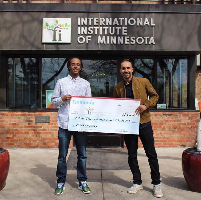 Mohamed Maalim (right) donates $1,000 to an organization that offers immigration and refugee resettlement services