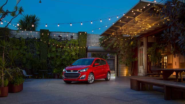 A red Chevrolet Spark under fairy lights 