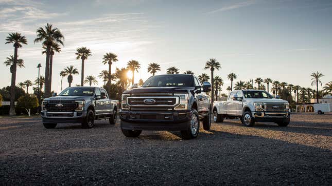 A photo of three Ford Superduty trucks parked in a row. 