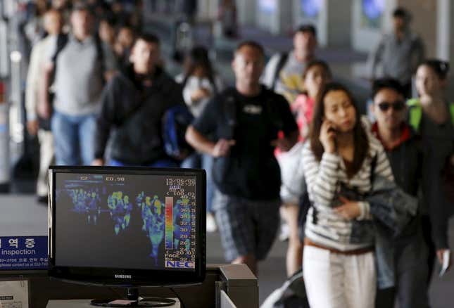 Passengers walk past a thermal imaging camera at Incheon International Airport.