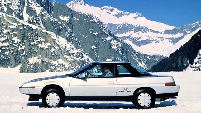 A photo of a silver Subaru XT in the mountains. 