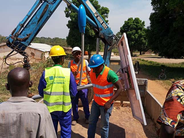 Solar technicians with Aptech Africa raise one of sixty-two solar streetlights they installed in Paoua, Central African Republic.