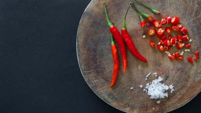 Thai chilis on a plate with a pile of salt.