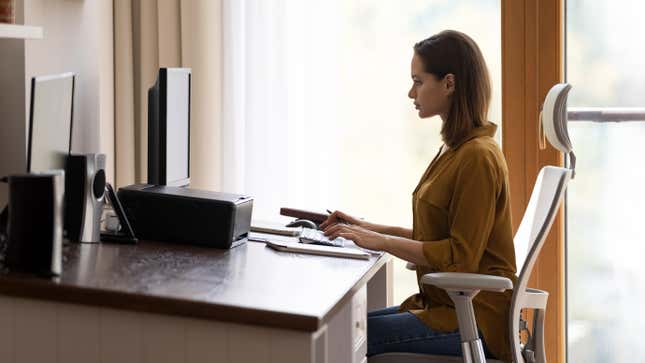 A young woman concentrates while working on a computer at a desk