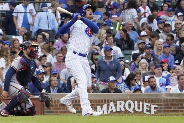 Aug 6, 2023; Chicago, Illinois, USA; Chicago Cubs center fielder Cody Bellinger (24) hits a single against the Atlanta Braves during the seventh inning at Wrigley Field.