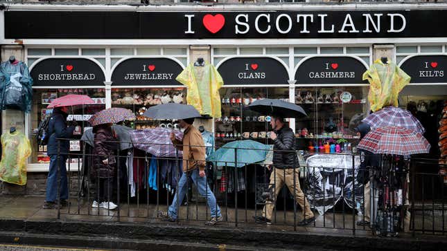 A photo of tourists in Edinburgh carrying umbrellas. 