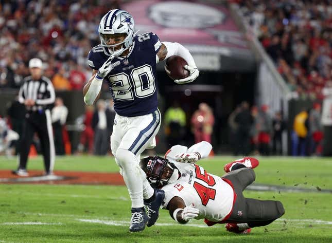 Jan 16, 2023; Tampa, Florida, USA; Dallas Cowboys running back Tony Pollard (20) breaks the tackle of Tampa Bay Buccaneers linebacker Devin White (45) in the first half during the wild card game at Raymond James Stadium.