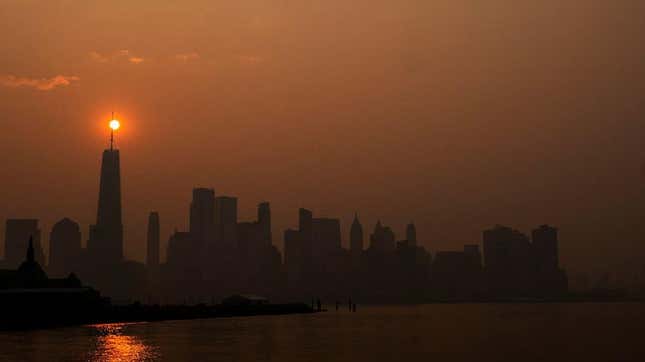 The sun rises behind the One World Trade Center, while the smoke from Canada wildfires covers the Manhattan borough as it is seen from Liberty State Park on June 8, 2023, in New Jersey.