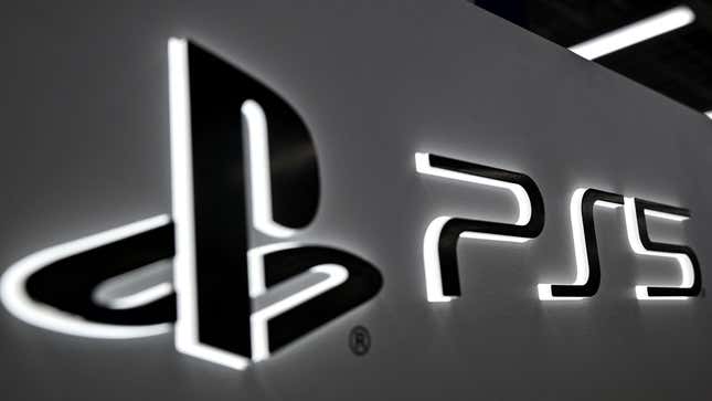 A PlayStation and PS5 logo are lit up on a whiteboard amid a dark office space. 