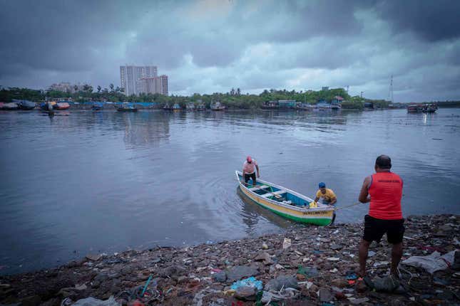A fisherman tugs at a boat in Versova creek, Mumbai.