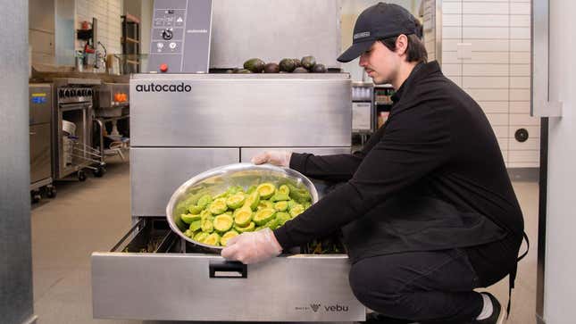 employee holding peeled avocado